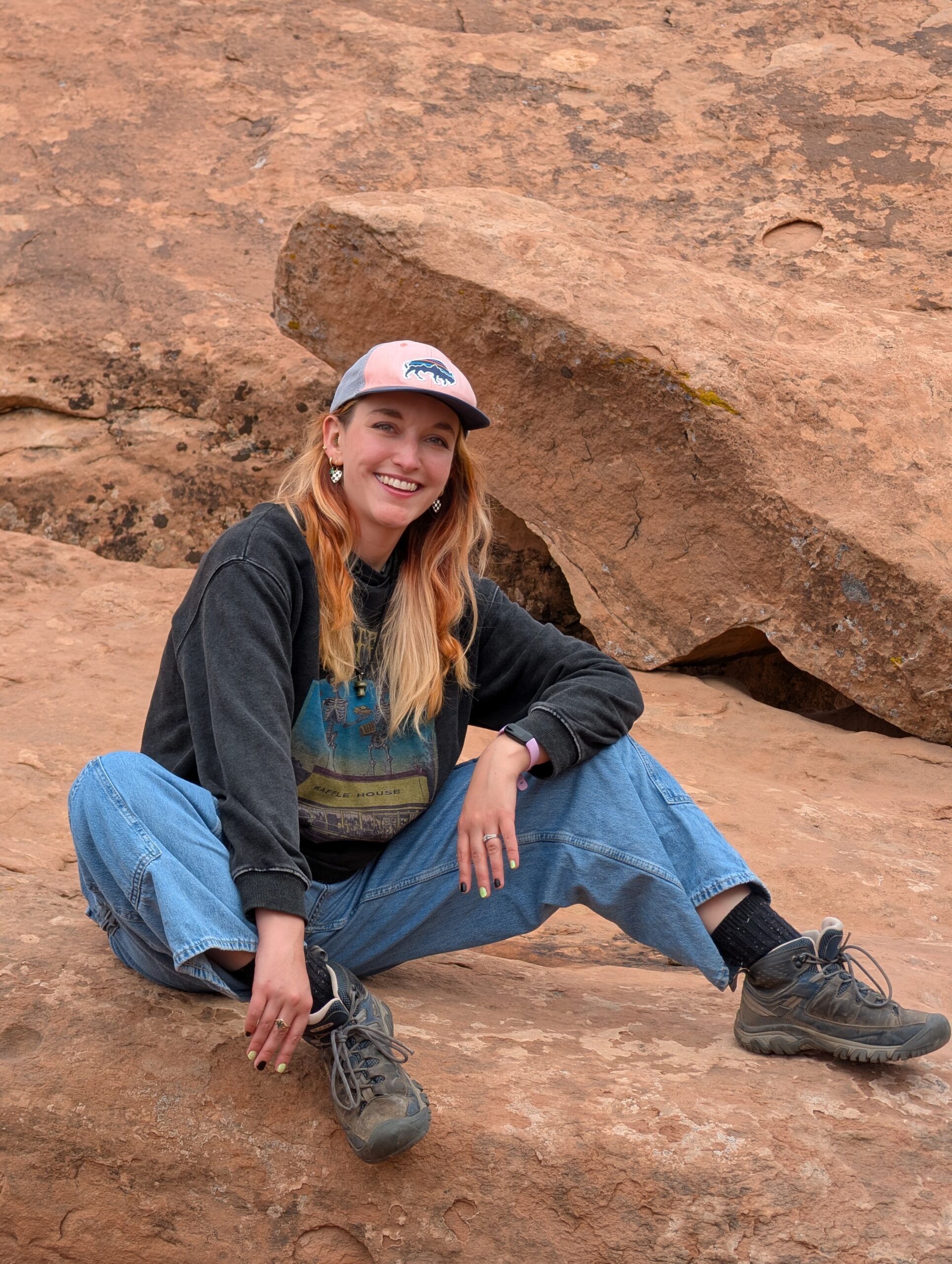 Carly Coleman sitting on red rock